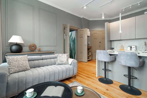 A cozy living room with a sofa and coffee table connected to a modern kitchen. Bright and stylish interior design.
