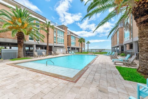 Sparkling pool framed by swaying palms offers your perfect tropical retreat, with comfy loungers and stunning water views just steps away.