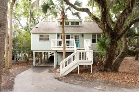 Tucked under a majestic canopy of moss-draped live oaks and palms, Sweet-Tee Cottage features an inviting elevated design with a private driveway and covered carport area underneath.