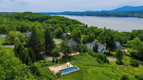An incredible high-altitude aerial view showcasing the estate’s rolling green acreage and proximity to the water.