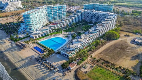 Stunning aerial view of the beachfront resort featuring pools, lush landscaping, and direct beach access. A perfect blend of luxury, comfort, and coastal living.