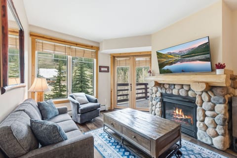 Settle into your mountain retreat where a crackling stone fireplace and stunning natural vistas create the perfect backdrop for your getaway. Floor-to-ceiling windows frame serene landscapes right from your cozy living space.