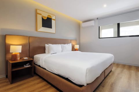 Cozy bedroom with a comfortable bed and warm lighting.