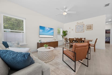 Comfy couch and smart TV in an open living space to kitchen and dining