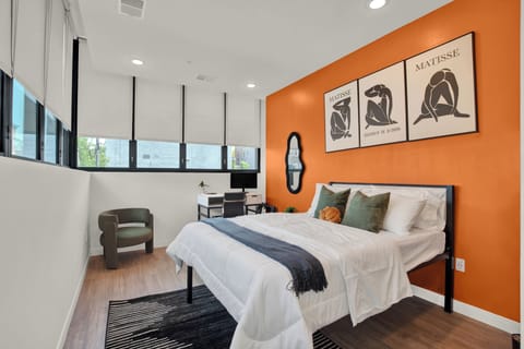 Bright modern bedroom with bold accent wall, workspace, and natural light