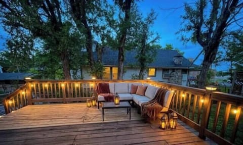 Cozy tree-lined deck with ambient lighting and comfortable lounge seating
