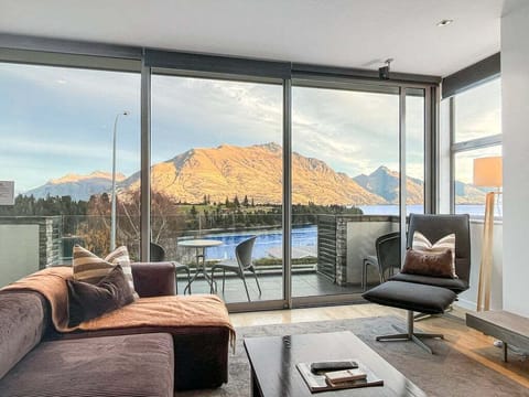 Floor-to-ceiling windows framing stunning lake and mountain views.