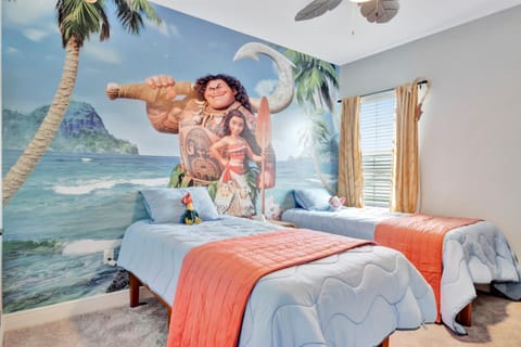 Two twin beds beneath a beach-themed mural wall
