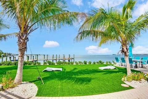 Tropical waterfront lawn with palm trees, dock, and relaxing bay views. Fishing Paradise.