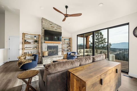 Unwind in your cozy living room with soaring ceilings, a stone fireplace, and stunning mountain views from your private balcony—your perfect escape awaits.