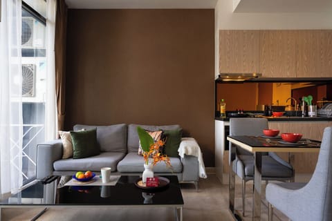 Bright modern living area with cozy seating, dining space, and sleek kitchen