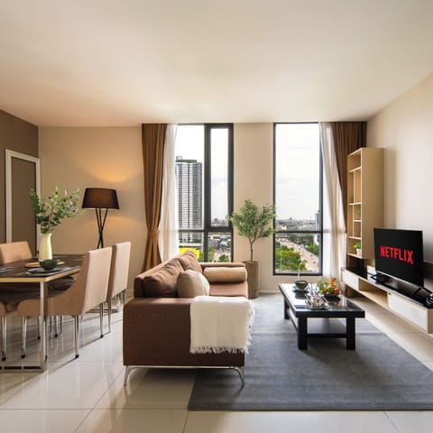 Bright city-view living room with dining area, large windows & Netflix