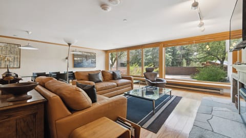 Sink into rich leather sofas and soak in the natural light streaming through floor-to-ceiling windows overlooking a peaceful garden. Your perfect retreat for relaxation awaits.