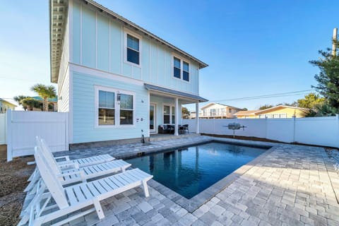 Your own private pool, a sun-drenched paver deck, and a crisp blue sky,  the backyard that makes everyone cancel their beach plans and stay right here.