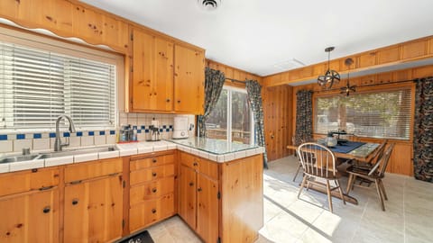 Kitchen with sliding door, dining table, counter, and sink.