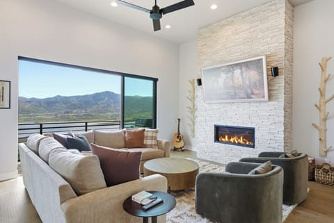 Cozy up by the fireplace while floor-to-ceiling windows frame sweeping mountain views.