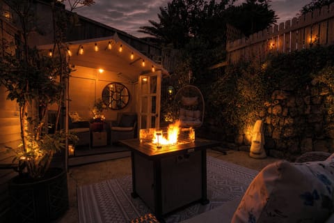 Private garden after dark with festoon lights, fire pit and seating
