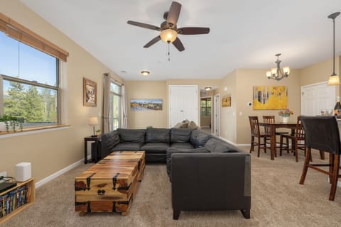 Relax in your spacious open-concept living and dining area, where natural light pours through large windows framing peaceful forest views, creating a warm, inviting retreat for memorable moments.