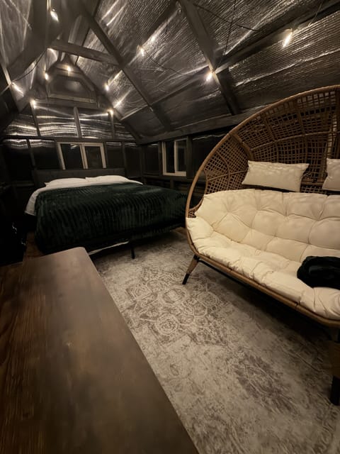 Cozy loft bedroom with vaulted ceilings, warm lighting, and a chic daybed