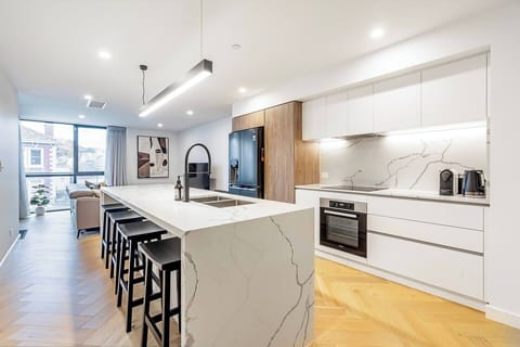 The kitchen island brings everyone together, offering an inviting spot for morning coffee, easy conversation, and an evening glass of wine before dinner.