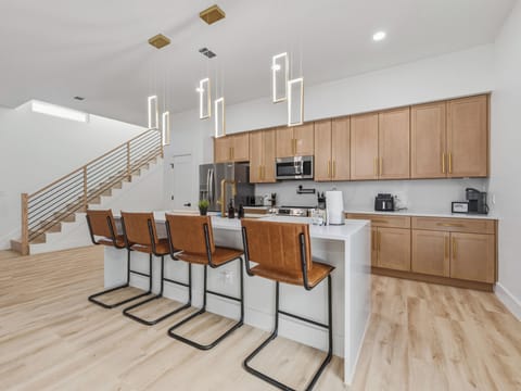 Picture yourself preparing meals in this spacious, sunlit kitchen where modern style meets comfort. The sleek island beckons you to gather with loved ones over coffee or cocktails.