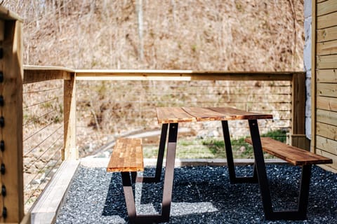 Gather around the rustic wooden picnic table surrounded by serene nature.