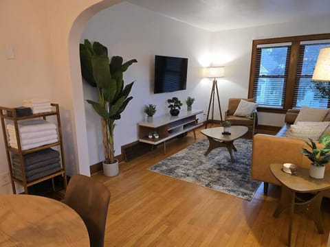 Cozy modern living room with hardwood floors, TV, and stylish seating