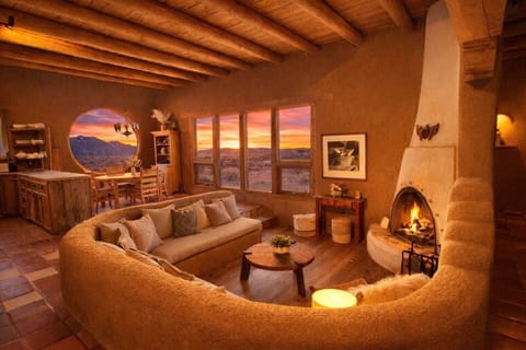 Gather by the kiva fireplace beneath soaring vigas with endless desert views.