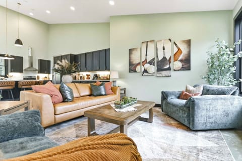 Relax into a bright, beautifully styled lounge where warm leather seating, soft textures, and an open chef-inspired kitchen create the perfect setting to gather, unwind, and feel at home.