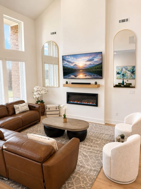 Bright vaulted living room with fireplace, TV, and stylish seating
