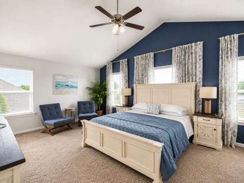 Bright, spacious king bedroom with vaulted ceilings and cozy seating