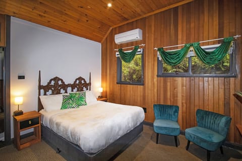 Cozy timber bedroom with leafy views, AC, and stylish seating