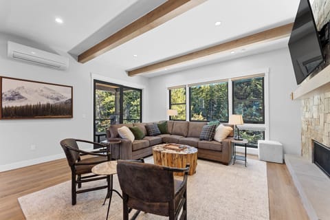 The living room features a gas fireplace, smart TV, & ample seating.
