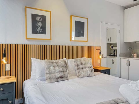 Comfortable king bed with warm timber accents and hotel-style comforts.