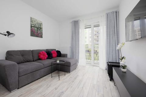 Bright living area with a comfortable corner sofa and direct access to the balcony.