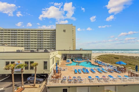 Beachfront pool deck with ocean views and easy access to the sand