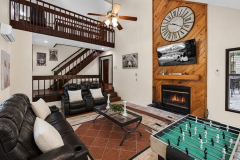 Spacious living room with soaring ceilings, fireplace, Smart TV, and foosball for fun family nights in.