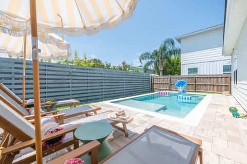 Private sunny pool oasis with loungers, umbrellas, and resort-style vibes