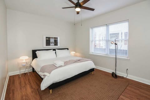 Sunlit bedroom with hardwood floors and minimalist décor.