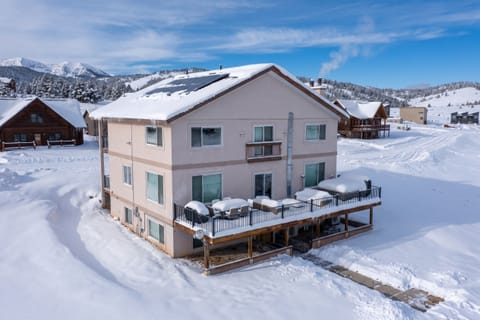 A spacious mountain retreat framed by snow-dusted peaks and pristine winter landscape, offering expansive decks and alpine access for your perfect ski getaway.