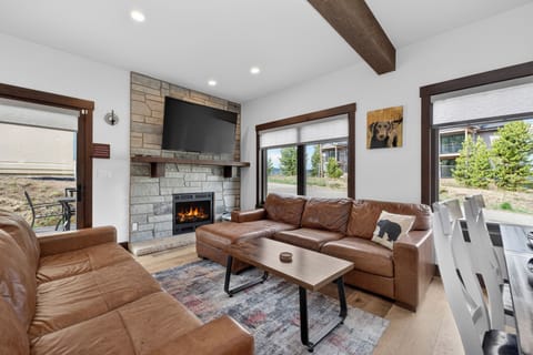 Settle into plush leather sofas by the warm fireplace, where rustic wood beams and mountain views through expansive windows create your perfect retreat.