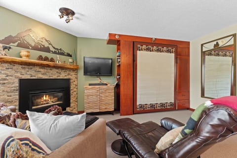 Relax in your inviting living space with a cozy fireplace, warm wood accents, and mountain-inspired décor that sets the perfect tone for a restful getaway.