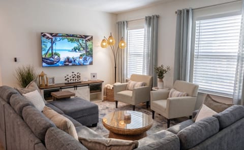 Bright open-concept living room flowing into kitchen & dining area.