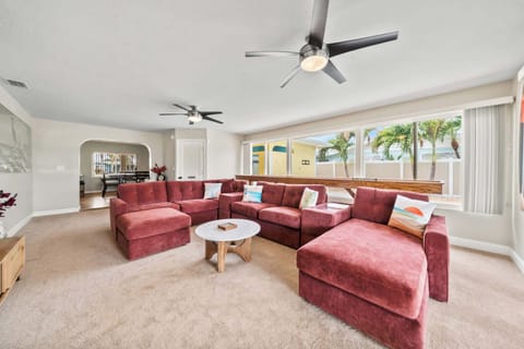 Spacious living room with a large sectional sofa and natural light from wide windows.