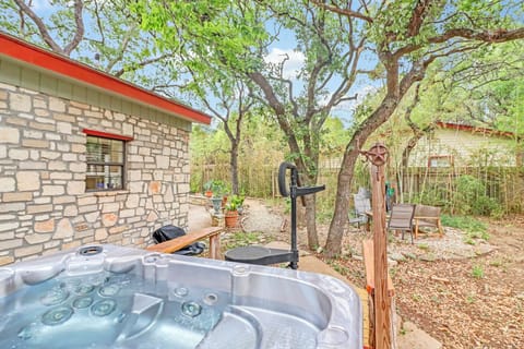 A wooded outdoor sanctuary with a hot tub beneath towering trees, offering your own private escape surrounded by nature and peaceful seating areas.