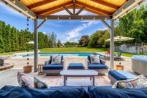The heart of the home—comfortable outdoor living with views of the pool, hot tub, and expansive backyard