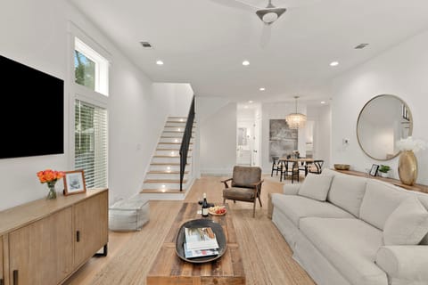 Bright, open-concept living area featuring high ceilings, tall windows, and a seamless flow to the dining space.