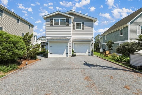 Modern coastal-style duplex featuring convenient on-site parking and a welcoming facade in a peaceful residential neighborhood.