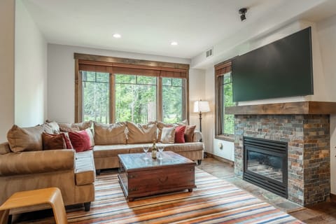 Sink into plush seating while the fireplace warms your space and natural light streams through forest-view windows, creating your perfect mountain retreat.