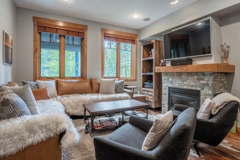 Sink into plush textures and rustic warmth as you unwind by the fireplace, surrounded by natural light and cozy seating designed for your complete relaxation.